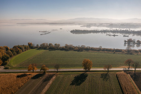Road on a sunny day in the countryside in Poland. Autumn empty road near the lake and trees.の写真素材