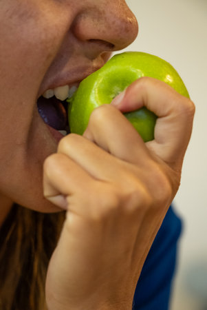 Woman eats food. Woman eats apple. Close shot of girl apples. Face while eating green apples.