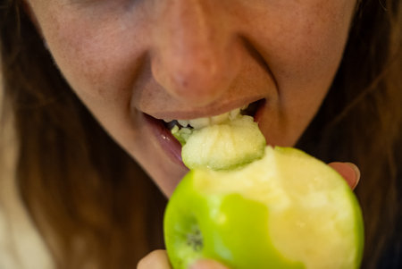 Woman eats food. Woman eats apple. Close shot of girl apples. Face while eating green apples.の写真素材