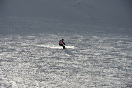 Freeride snowboarding in winter. Freeride heliboarding. Riding in powder on snowboard. Ski, snowboard freeride and deep powder snow. Gudauri Georgia Caucasus resort. Freeride in Caucasus mountains.の写真素材
