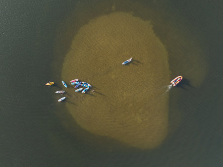 Aerial drone view of People swimming on sup on the lake. Stand Up Paddle on the lake. Large group of people on sup boards on the lake.の写真素材