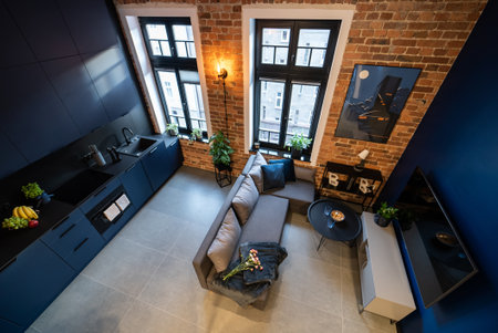 Stylish kitchen seamlessly connected to a cozy living room. Modern kitchen connected to the living room in a small apartment. Modern furnished kitchen with household appliances and a dining room.の写真素材