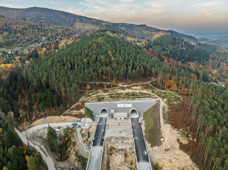 Aerial drone view of unfinished highway construction site in mountains during autumn. Construction of expressway in the mountains. Construction of a highway with viaducts and tunnels in the mountainsの写真素材