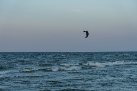 People swim on the sea on a kiteboard or kitesurfing. Summer sport learning how to kitesurf. Kitesurfing lessons on the bay.Kite surfing on bay. Hel Peninsula, Puck bay, Jastarnia, Poland.の写真素材