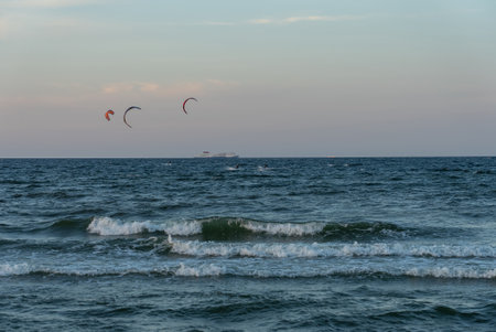 People swim on the sea on a kiteboard or kitesurfing. Summer sport learning how to kitesurf. Kitesurfing lessons on the bay.Kite surfing on bay. Hel Peninsula, Puck bay, Jastarnia, Poland.の写真素材