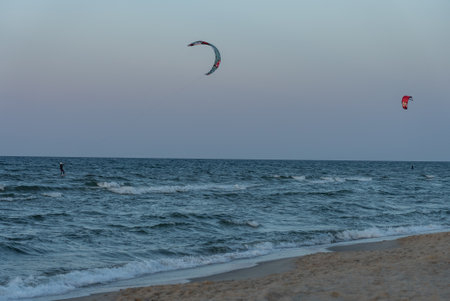 People swim on the sea on a kiteboard or kitesurfing. Summer sport learning how to kitesurf. Kitesurfing lessons on the bay.Kite surfing on bay. Hel Peninsula, Puck bay, Jastarnia, Poland.の写真素材