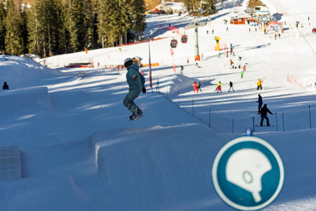 Snow park box tricks. Snowboarder in park on a box. Winter jibbing in snwopark. Snowboard lessons on...