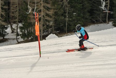 Group of people skiing in the mountains on a sunny winter day. Ski lessons with local instructors. Children learn to ski with an instructor. Children's skiers in the Dolomites Alps.の写真素材
