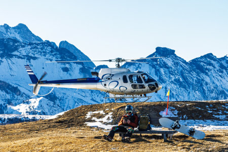 Helicopter on a snowy mountain helipad with a picturesque alpine backdrop. Sightseeing flights over the Dolomites and Alps. The helicopter is standing on a landing field in the mountains.の写真素材