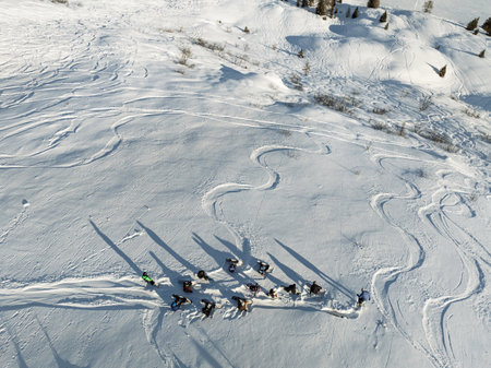 Aerial drone view of group of snowboarders getting ready for a winter descent. Group of snowboarders in the mountain. Sunny winter day in the dolomites.の写真素材