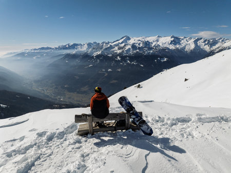 Aerial drone view of sunny winter in dolomites, alps. Aerial drone view of person on top of mountain with snowboard, mountain view in sunny winter day.の写真素材