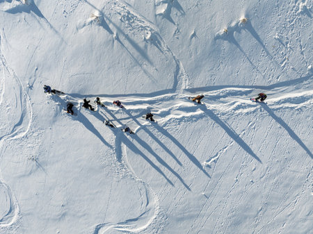 Aerial drone view of group of snowboarders getting ready for a winter descent. Group of snowboarders in the mountain. Sunny winter day in the dolomites.の写真素材