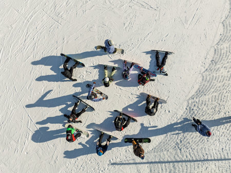 Aerial drone view of group of snowboarders getting ready for a winter descent. Group of snowboarders in the mountain. Sunny winter day in the dolomites.の写真素材