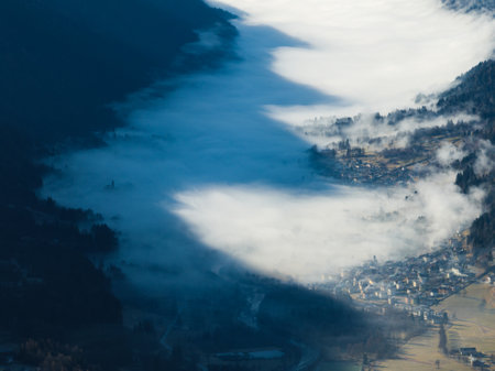 Aerial drone view of sunny winter in alps. Pinzolo village and a ski resort in Italy. Brenta, town in Dolomites covered in fog, view from a drone.の写真素材