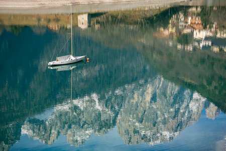 Sailboat, yacht on crystal clear lake in the Brenta Dolomites. Aerial drone view of Lake Molveno, beautiful lake in Italy. Lake in dolomites from drone in winter. Lake Molveno in Italy.の写真素材