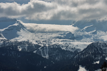 View of sunny winter in dolomites, alps. Madonna di Campiglio village covered in fog and clouds a ski resort in Italy. Madonna di Campiglio ursus snowpark in Val Rendena dolomites trentino Italy.の写真素材