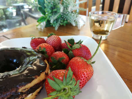 strawberries and Chocolate dough with hot tea at the backの写真素材