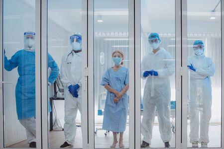 Dortor, Nurse and patient looking out in the quarantine room from case of coronavirus covid 19. Virus infected patient with outbreak at hospital with coronavirus covid 19 disease treatment.の写真素材