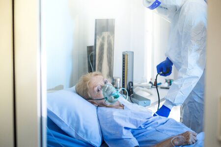Infected patient lying on bed in hospital under care of Medical team with X-rays Lung in quarantine room from coronavirus covid 19 disease.の写真素材