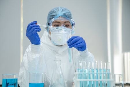 Scientist in laboratory with test tubes on Covid19 Coronavirus type for discover vaccine.