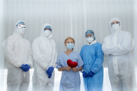 Victory of Doctor & nurse team just recovered patient in hospital. Recovering patient and medical team win virus Covid-19 outbreak. Health Insurance, happy patient, teamwork Raise hand sucess conceptの写真素材