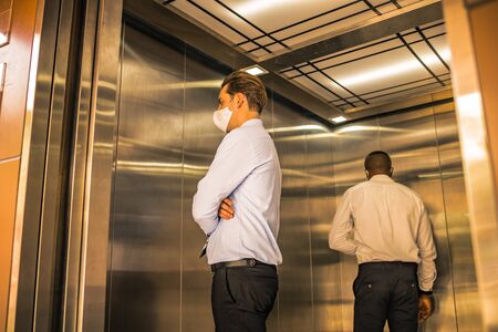 Social Distancing on Elevator with 4 passengers stand in the corner from outbreak of coronavirus covid19 situation. Concept of aware safe and low risk.の写真素材