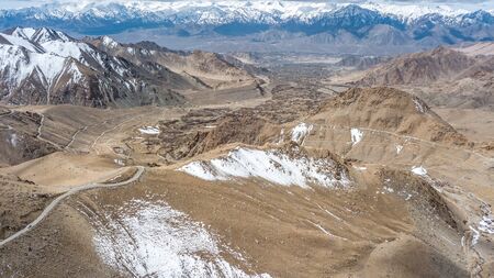 Natural Atmosphere of Leh Ladakh City, Jammu, north of India in Winter. Rock Mountain with Snow cover to Himalayas mountains, one of Highest road in the world. Photo from aerial view by drone.の写真素材