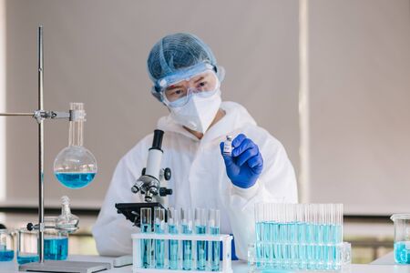 Scientist in laboratory with test tubes on Covid19 Coronavirus type for discover vaccine.