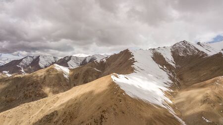 Natural Atmosphere of Leh Ladakh City, Jammu, north of India in Winter. Rock Mountain with Snow cover to Himalayas mountains, one of Highest road in the world. Photo from aerial view by drone.の写真素材