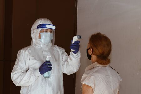 Line up for Social distancing concept. Officer use infrared forehead thermometer to check fever body temperature for virus symptoms. Respiratory diseases such flu covid19, coronavirus.の写真素材