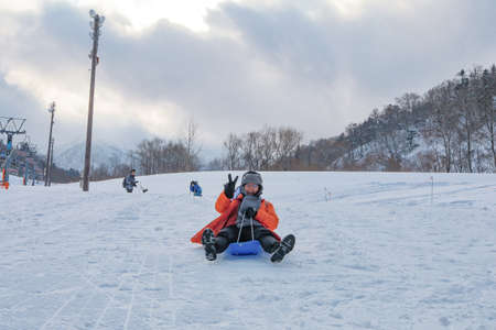 Hokkaido, Japan - December 2019 : Photo of a family and children are playing ski sliders together in...