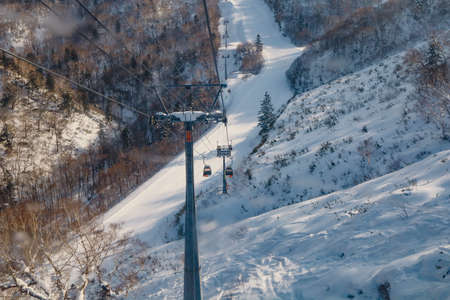Hokkaido, Japan - December 2019 : Area of Kiroro ski resort. Skiers and Snowboarders Ride the Gondola at Kiroro Ski Resort during winter with fully of snow ground in Hokkaido, Japan.のeditorial素材