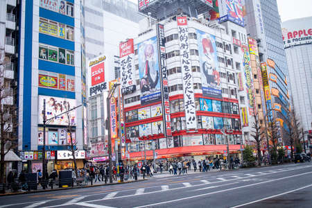 Tokyo, Japan - February 2020: Neon lights and billboard advertisements on buildings at Akihabara at rainy night. Akihabara is a shopping district for video games, anime, manga, and computer goods.のeditorial素材