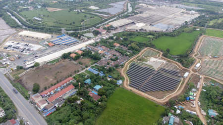 Aerial panorama view over a modern solar farm and green farm around. Solar panels station for...