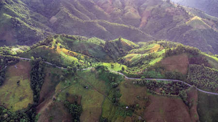 Aerial view of sky road over top of mountain with fog and green jungle after raining in morning, doi...