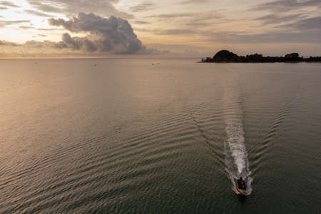 Aerial bird eyes view of jet ski boat cruising in high speed in turquoise clear water sea.の写真素材