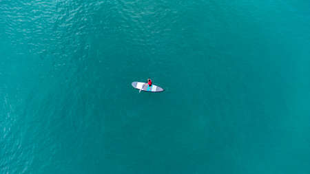 Gulf of Thailand - Ocotber 2021 : Unidentified man on sea Kayaker Aerial View. Caucasian Sportsman in the Yellow and Blue Kayak Paddling on the Scenic sea Along the Shore.のeditorial素材