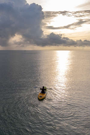Gulf of Thailand - Ocotber 2021 : Unidentified man on sea Kayaker Aerial View. Caucasian Sportsman in the Yellow and Blue Kayak Paddling on the Scenic sea Along the Shore.のeditorial素材