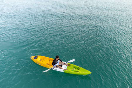 Gulf of Thailand - Ocotber 2021 : Unidentified man on sea Kayaker Aerial View. Caucasian Sportsman in the Yellow and Blue Kayak Paddling on the Scenic sea Along the Shore.のeditorial素材