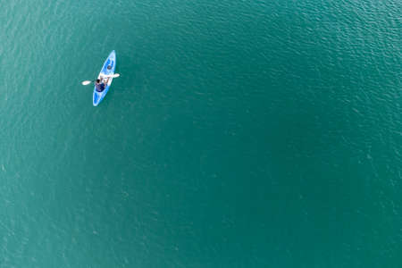 Gulf of Thailand - Ocotber 2021 : Unidentified man on sea Kayaker Aerial View. Caucasian Sportsman in the Yellow and Blue Kayak Paddling on the Scenic sea Along the Shore.のeditorial素材