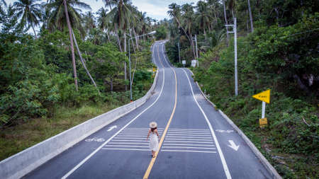 Unidentified woman walking on beautiful Road Khanom Sichon Road at Khao Phlai Dam view point. Shot by Drone Aerial View at Nakorn Sri Thammarat province, Thailandの写真素材