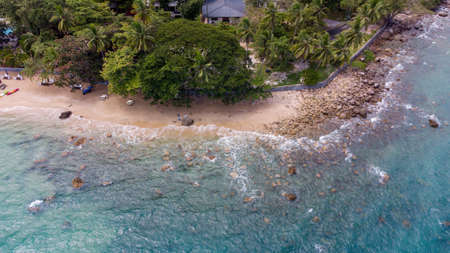 Aerial view of clear turquoise sea on sandy beach and ocean with waves.