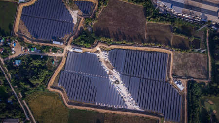 Aerial view of a solar farm producing clean energy during the evening with twilight and visible all...