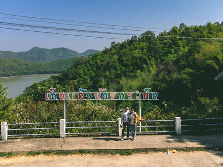 Loei Province, Thailand - December 2021 : Couple in Area of Huai Krathing reservoir with bamboo raft shelter for Rafting and Eating. Beautiful natural landscape of the river and mountain with blue skyのeditorial素材