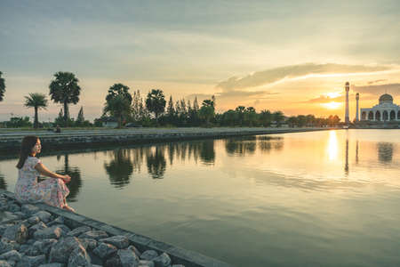 Beautiful girl watching on Landscape of beautiful sunset sky at Central Mosque in Songkhla province,...
