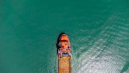 Aerial view on top of cargo ship carrying container and running for export cargo yard port to international custom ocean. Concept of technology transportation , customs clearance,の写真素材