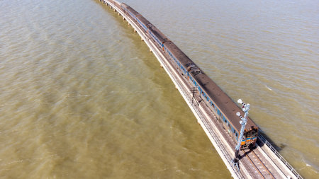 Aerial view of an amazing travel train parked on a floating railway bridge over the water of the...