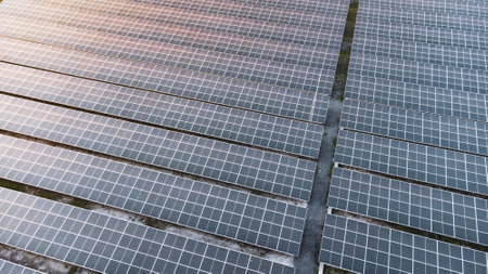 Fly over Solar cells on the roof of a large industrial factory. Solar roofs are generating renewable...