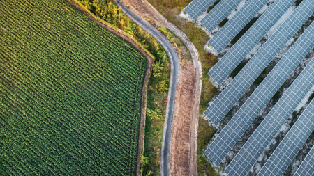 Fly over Solar cells farm beside nature green farm around large industrial factory area. Solar farms...