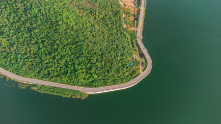 Muak Lek reservoir in Saraburi from aerial bird eye view. Beautiful unseen nature at Muak Lek dam with roadway beside with water and tree hill.の写真素材